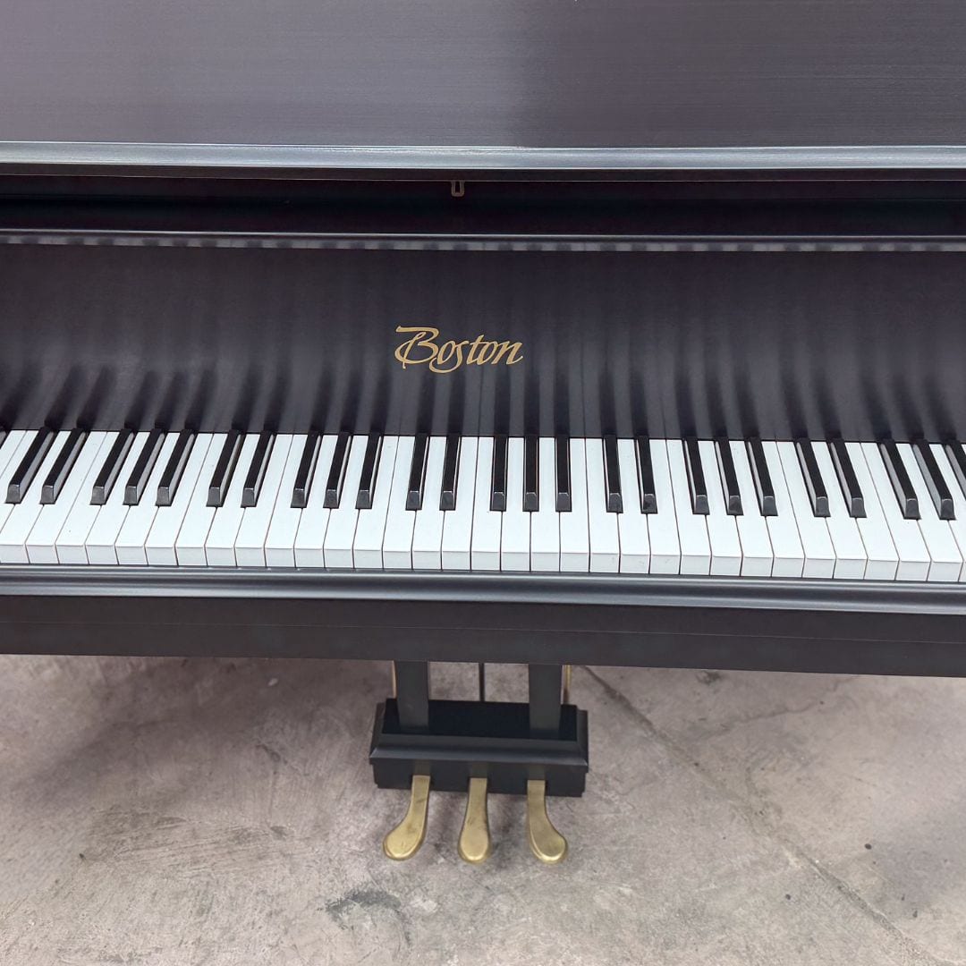The restored Boston grand keyboard straight on, with the gold Boston decal and brass pedal lyre